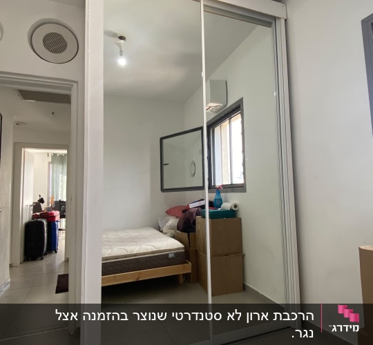 ארון בגדים לבן עם דלתות הזזה ומראה שהורכב בחדר